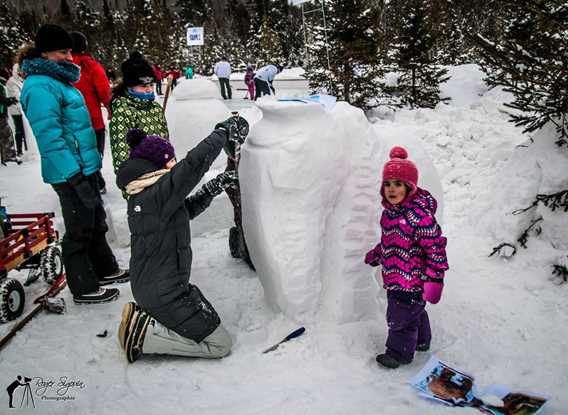 Children playing in the snow at Féérie d'hiver de Saint-Donat