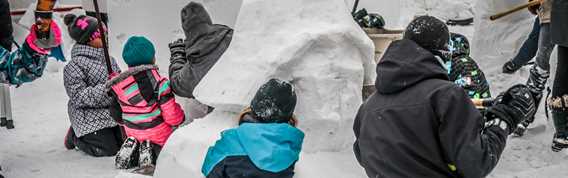 Enfants fabricant un igloo à la Féérie d'hiver de Saint-Donat