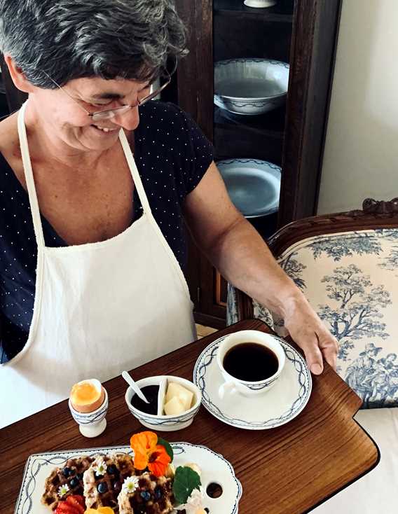 Dame qui sert le déjeuner au gîte Chêne et capucine