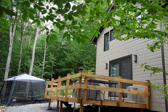 Mini-Chalet avec tente moustiquaire et table à l'intérieur