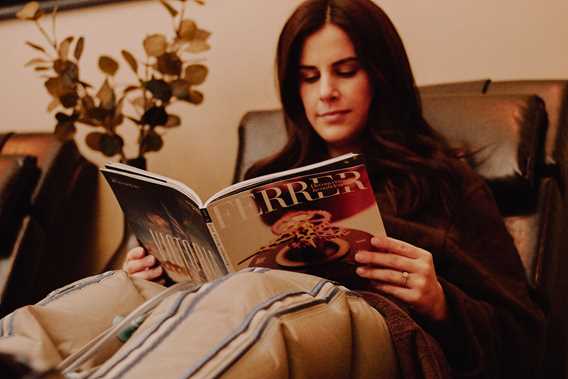 Woman relaxing while reading a magazine at Spa Santé