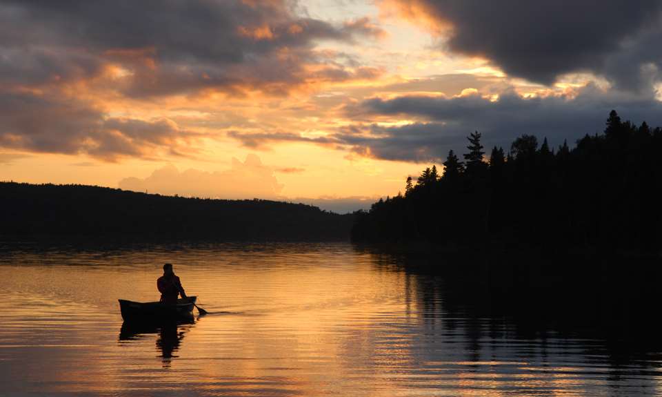A man on a canoe at Parc national du Mont-Tremblant during a sunset