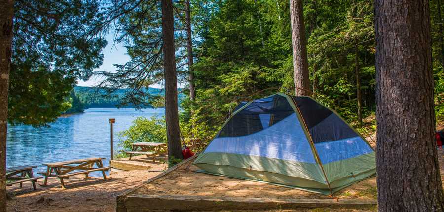 A lakeside tent with picnic tables at the Parc national du Mont-Tremblant