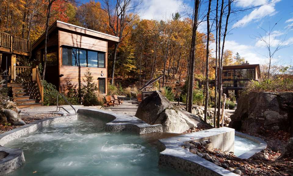 La vue totale de la Source Bains Nordiques avec les cabanes et la forêt