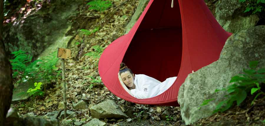 Femme qui relaxe dans un hamac à la Source Bains Nordiques