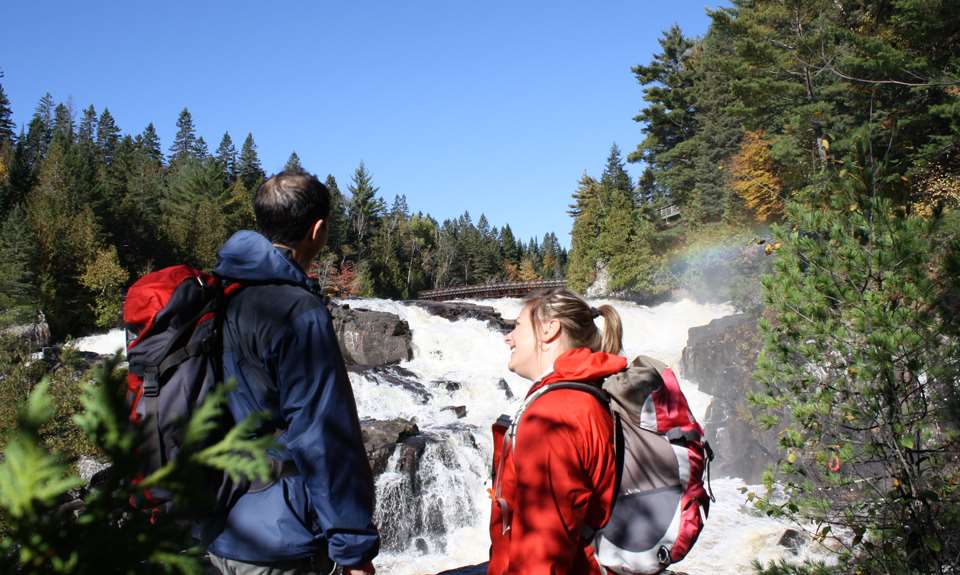 Couple qui rient devant une chute au parc régional des Chutes Monte-à-Peine-et-des-Dalles