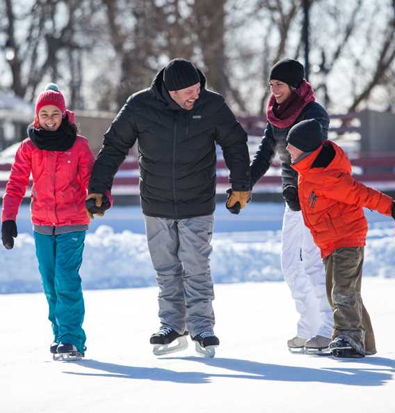 Family ice-skating together at Île-des-Moulins