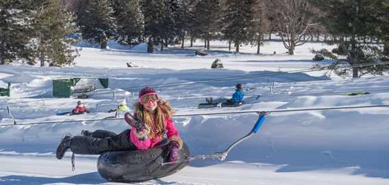 Enfant qui monte avec un tube aux Super glissades Saint-Jean-de-Matha
