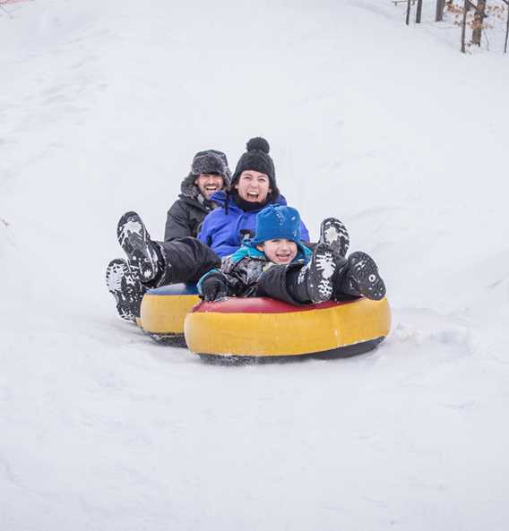 Famille qui s'amuse aux glissades chez Chalets Lanaudière