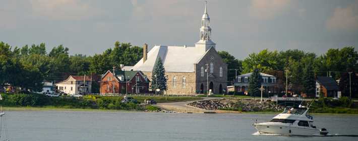 Vue extérieure sur le fleuve avec un bateau et église sur la Côte