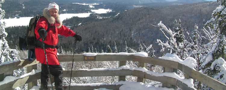 Un homme qui fait de la raquette au sommet du sentier l'Envol au parc national du Mont-Tremblant