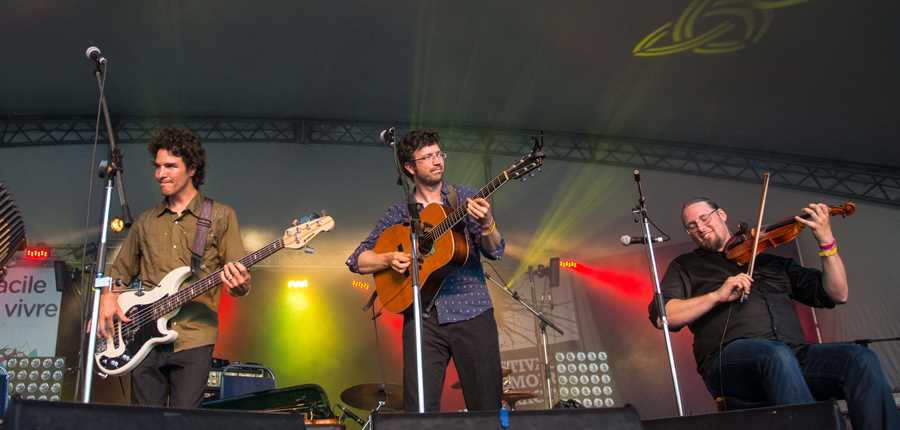 A group in front of a crowd at the Festival Mémoire et Racines