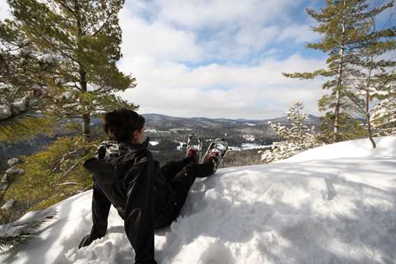 A woman snowshoeing to the top of Lac Blanc