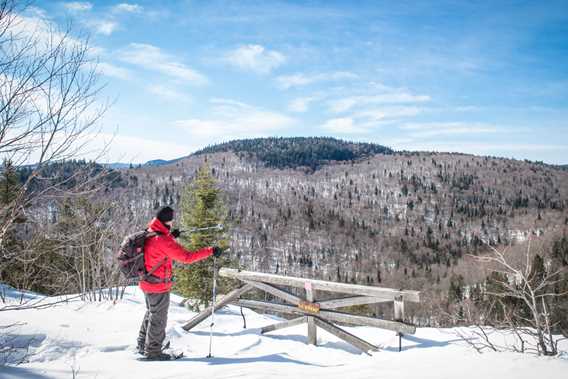 A man snowshoeing on the top of the trail Mont-Brassard