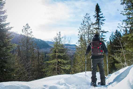 A man snowshoeing at the top on the trail Mont-Brassard