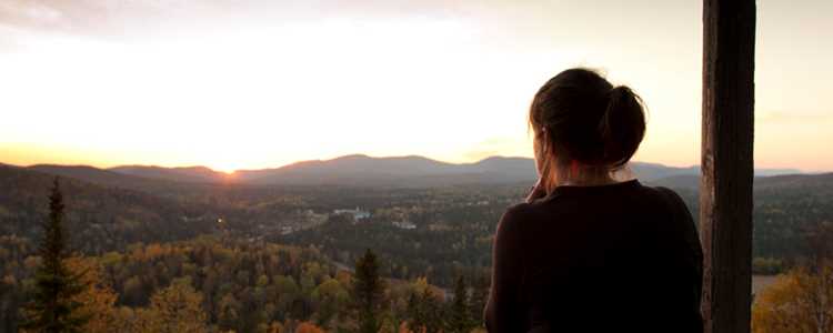 Une femme au sommet du sentier belvédère de la Croix avec une vue des montagnes