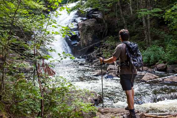 Homme devant une chute d'eau sur le Sentier Swaggin