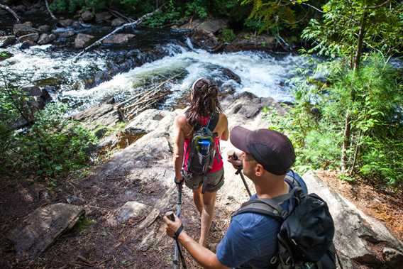  Couple hiking on the Swaggin Trail and arrives in front of a waterfall