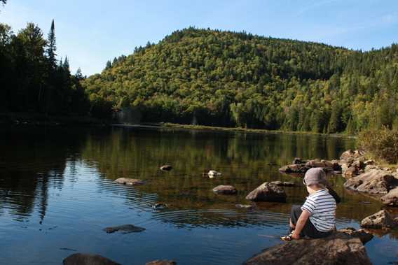 Child at the water's edge on the Mont-Brassard Trail in Sept-Chutes Regional Park