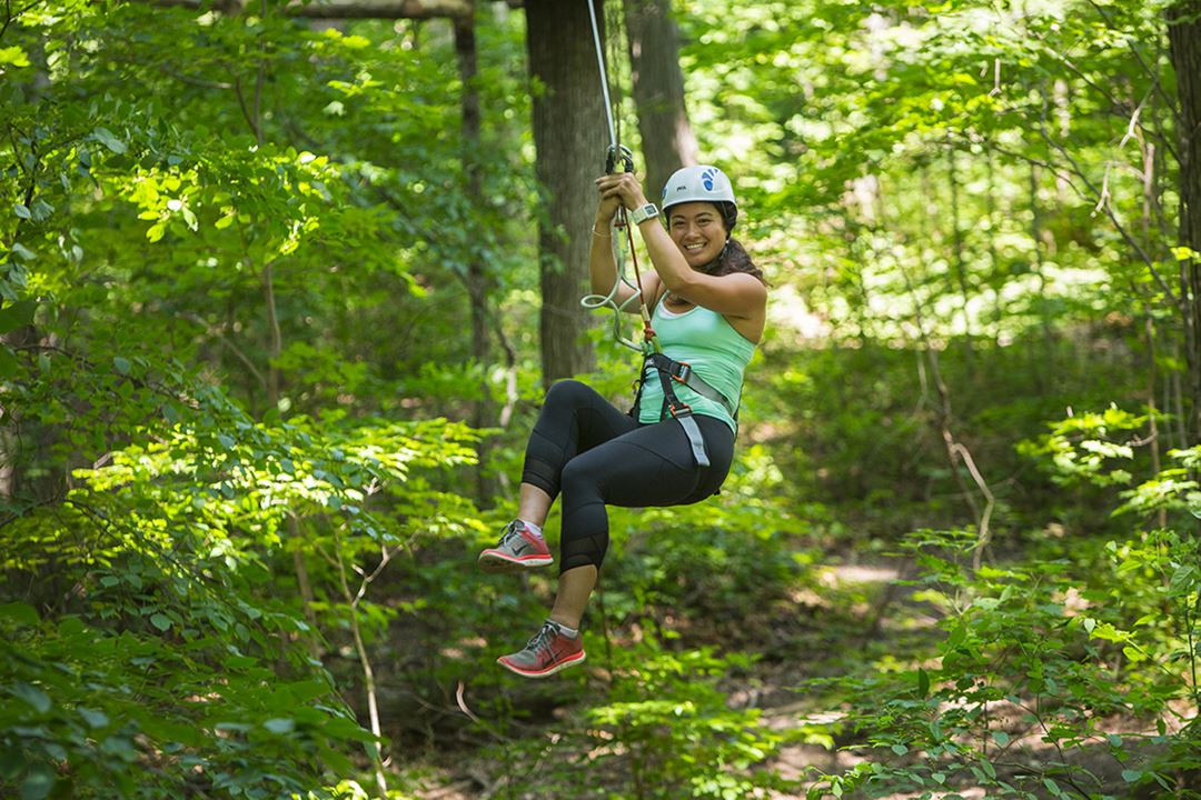 Girl using zip line at Arbraska