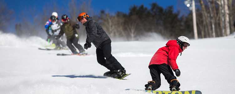 Skateboarders and skiers at Ski Val Saint-Côme