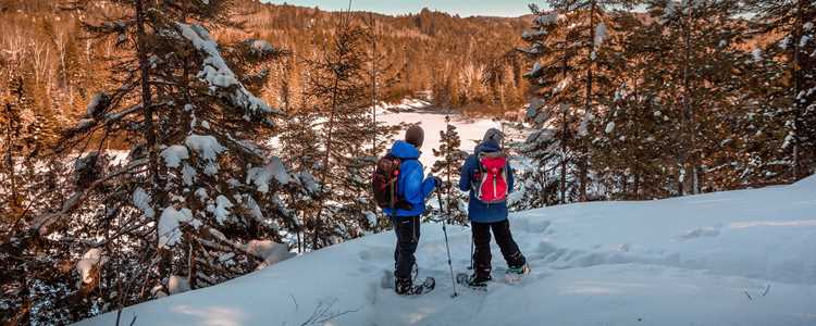 Two people snowshoeing in Swaggin trail in Saint-Côme