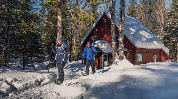 Two people snowshoeing in Swaggin trail in Saint-Côme