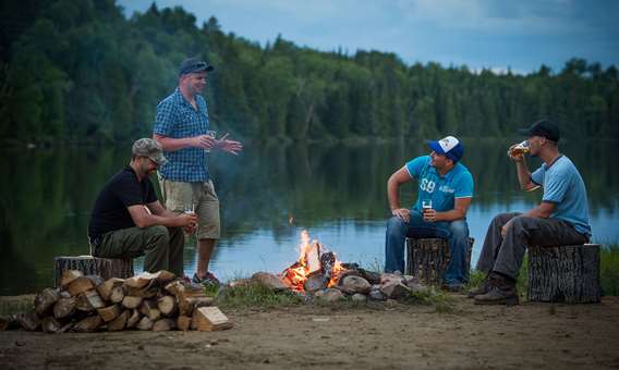 Des amis autour du feu en pourvoirie