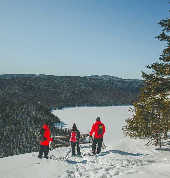3 snowshoers with a view of Lake Rémy