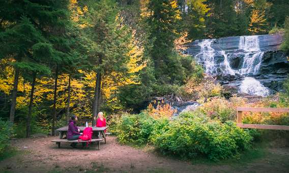 Two people watching a waterfall